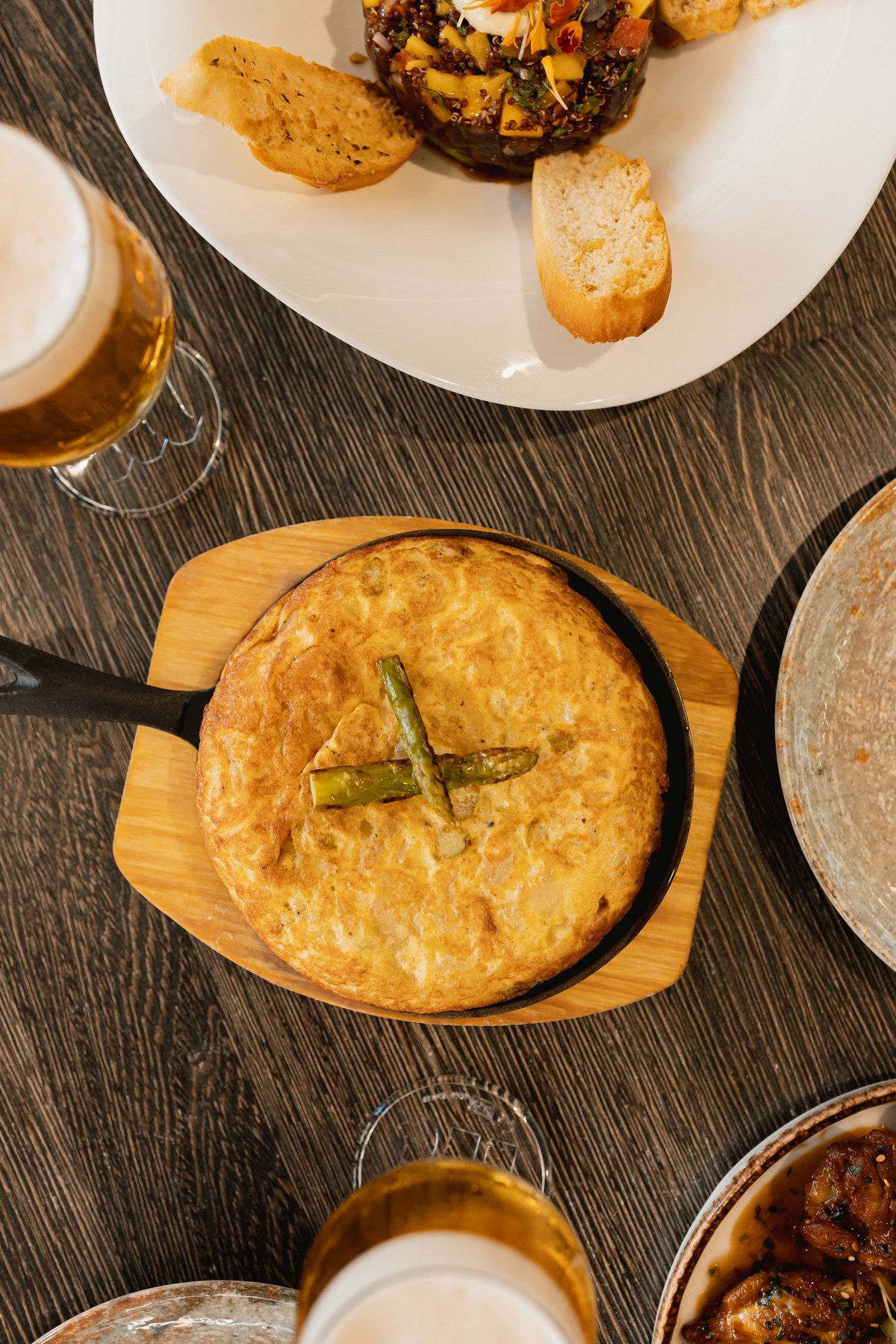 Tapas table with Spanish omelette, steak tartare and draught beers at Can Frasquet